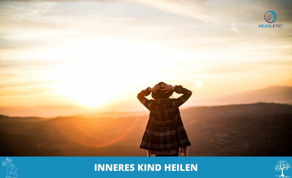 Eine heitere Gestalt mit Hut steht auf einem Hügel und blickt auf den leuchtenden Sonnenuntergang, ein Moment der Ruhe. Der Text unten lautet „INNERES KIND HEILEN“ und erinnert uns an die Reise, unser inneres Kind inmitten der Schönheit der Natur zu heilen.