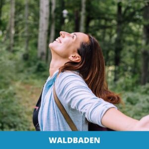 Eine Frau steht auf einem Waldweg mit ausgestreckten Armen und zurückgelegtem Kopf und genießt die Ruhe Waldbadens zwischen hohen Bäumen. Auf dem blauen Banner unten steht "WALDBADEN.