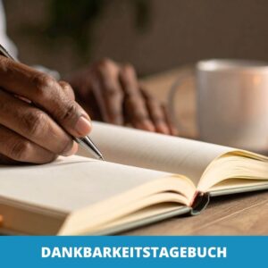 Eine Person schreibt in ein aufgeschlagenes Notizbuch neben einer Tasse und brennenden Kerzen, die das friedliche Ritual symbolisieren, während der Text "DANKBARKEITSTAGEBUCH" dazu einlädt, ein Dankbarkeitstagebuch zu führen.