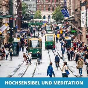 Eine belebte Straße mit Straßenbahnen, Geschäften und Menschenmassen; leuchtende Schilder umrahmen die lebhafte Szene. Der Text am unteren Rand lautet "HOCHSENSIBEL MEDITATION" und hebt einen achtsamen Ansatz für sensible Menschen inmitten des städtischen Chaos hervor.