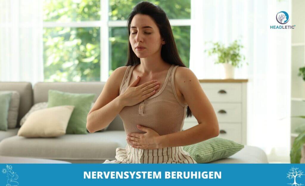 Eine Frau sitzt in einem Haus, eine Hand auf der Brust, die andere auf dem Bauch, die Augen geschlossen, und scheint tiefes Atmen zu üben, um ihr Nervensystem zu beruhigen. Der Text lautet: "Nervensystem beruhigen.
