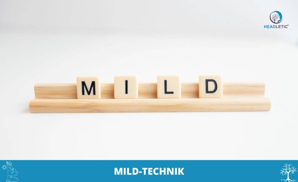Auf einem Holzgestell bilden Scrabblesteine das Wort „MILD“, was das MILD-Technik-Thema subtil widerspiegelt. In der Ecke ist ein Logo zu sehen.