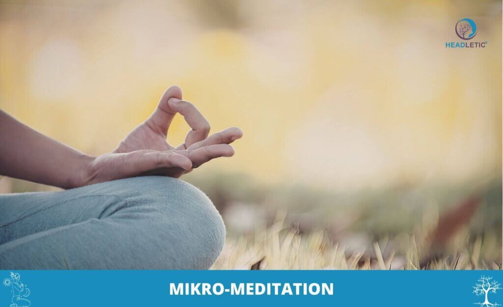 Eine Person sitzt im Freien im Schneidersitz und hält eine Hand in einer Meditationsgeste, die Ruhe und Konzentration verkörpert. Unten steht das Wort "MIKRO-MEDITATION", das auf die Kraft der Mikro-Meditation im täglichen Leben hinweist.